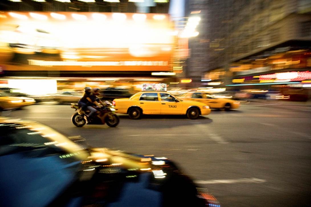 A yellow taxi and a motorcycle in a busy city street
AI-generated content may be incorrect.